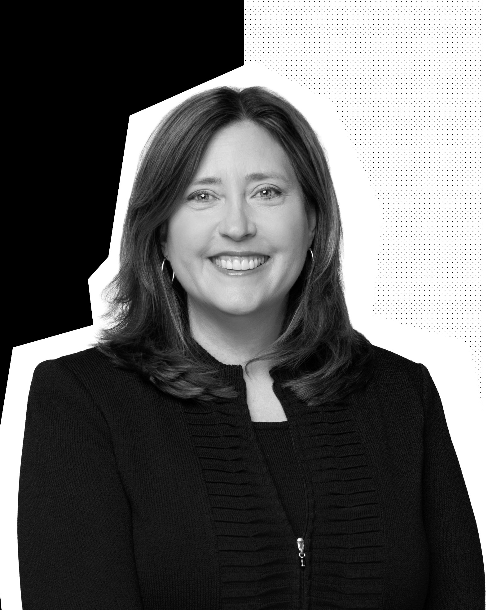 A black-and-white headshot of a smiling woman in a dark jacket.