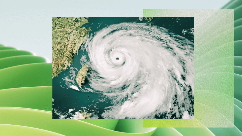 Satellite view of a large swirling hurricane over the ocean near a coastline, showing a distinct eye at the center and spiral cloud bands.