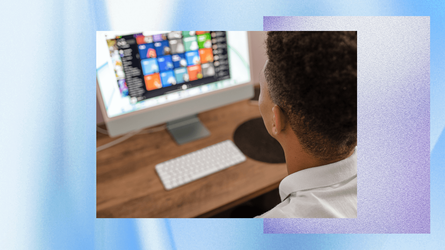 Person sitting at a desk looking at a computer screen displaying colorful app icons.