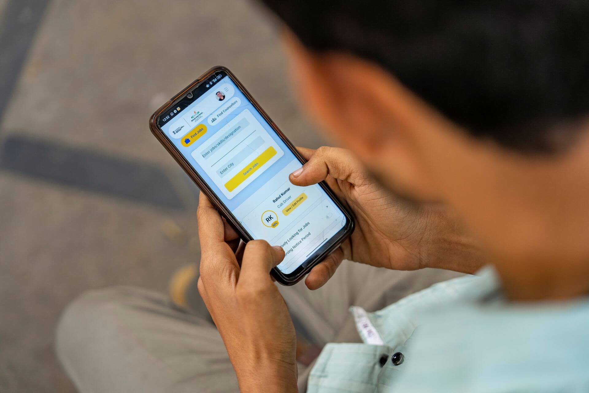 Person holding a smartphone showing an app screen with OTP entry and verification options.