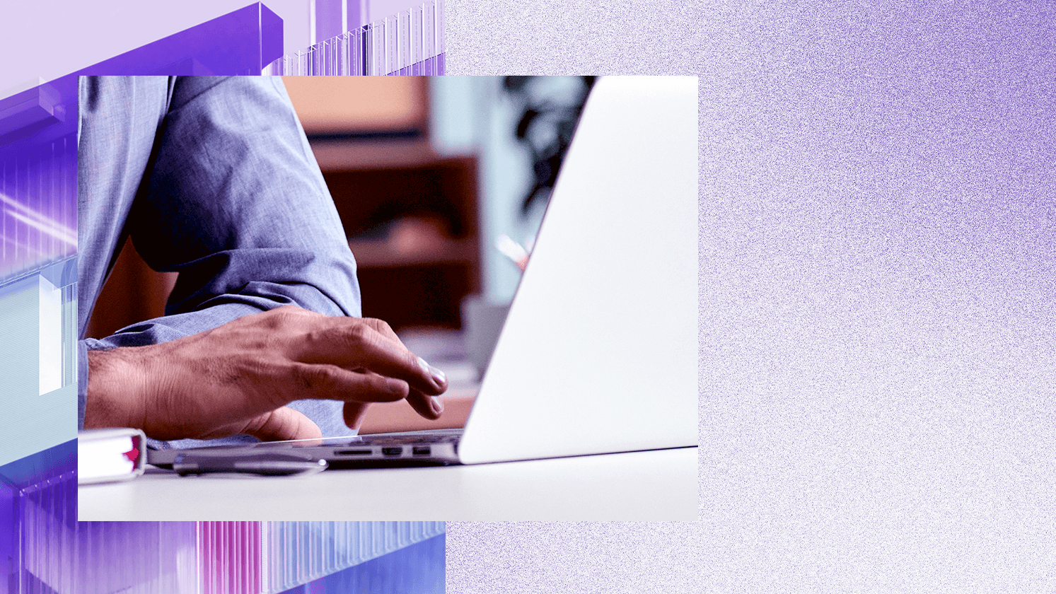 Close-up of a person typing on a laptop at a desk.