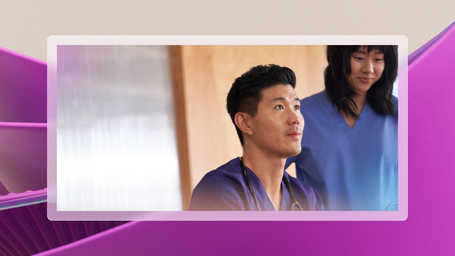 Two healthcare professionals in blue scrubs in a clinical setting.