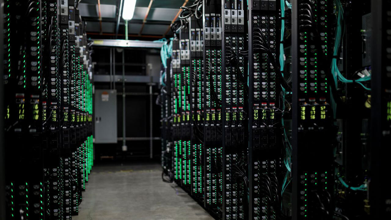 Rows of server racks with glowing green lights in a data center.