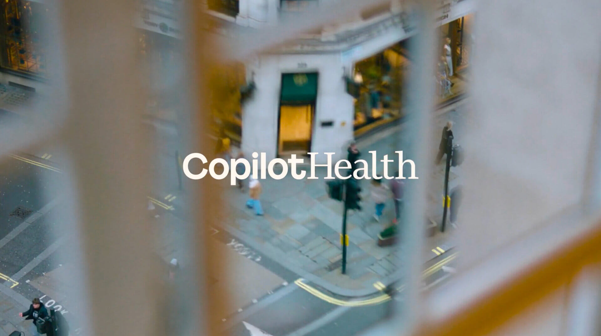 Blurred city street scene with the word ‘Copilot Health’ centered on the image.