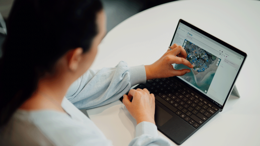 Person using a tablet to interact with a digital map on the screen.