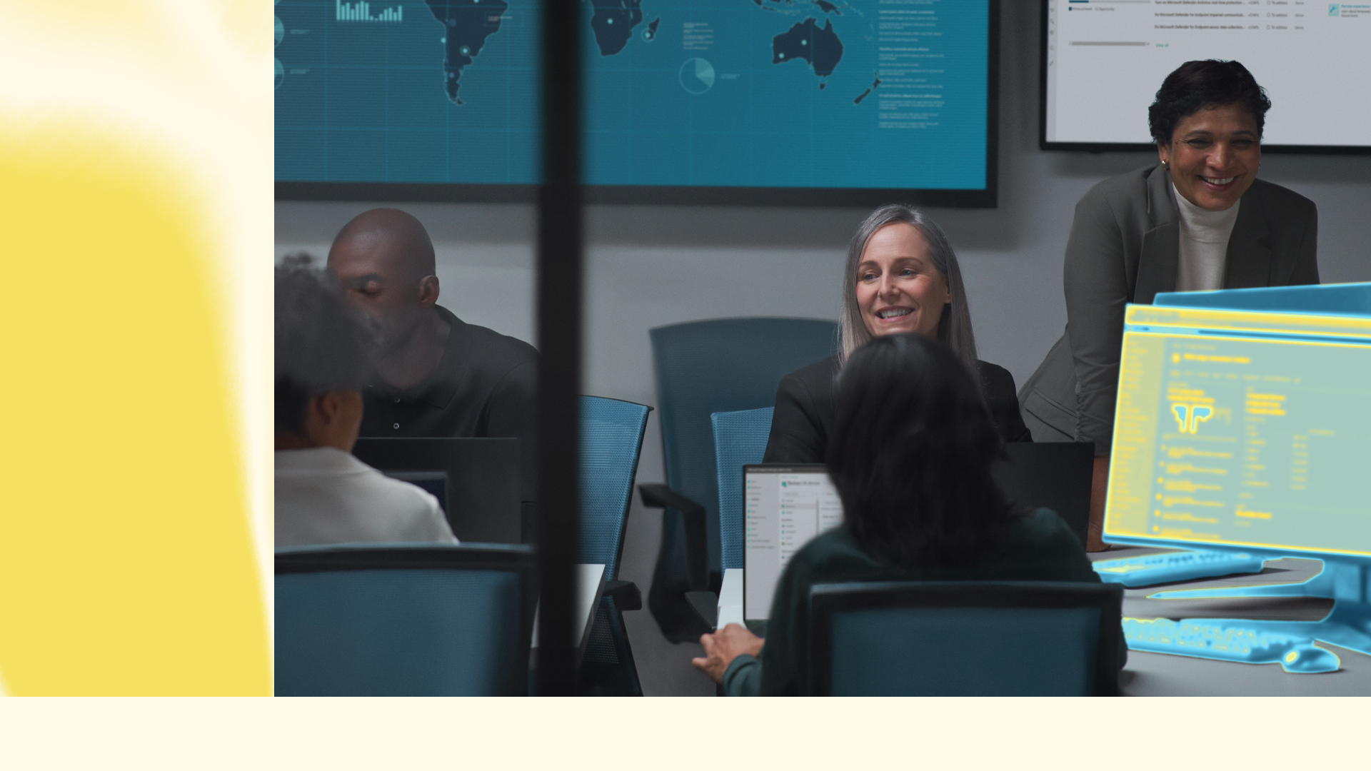 Team meeting in conference room with laptops and security dashboard on screen.