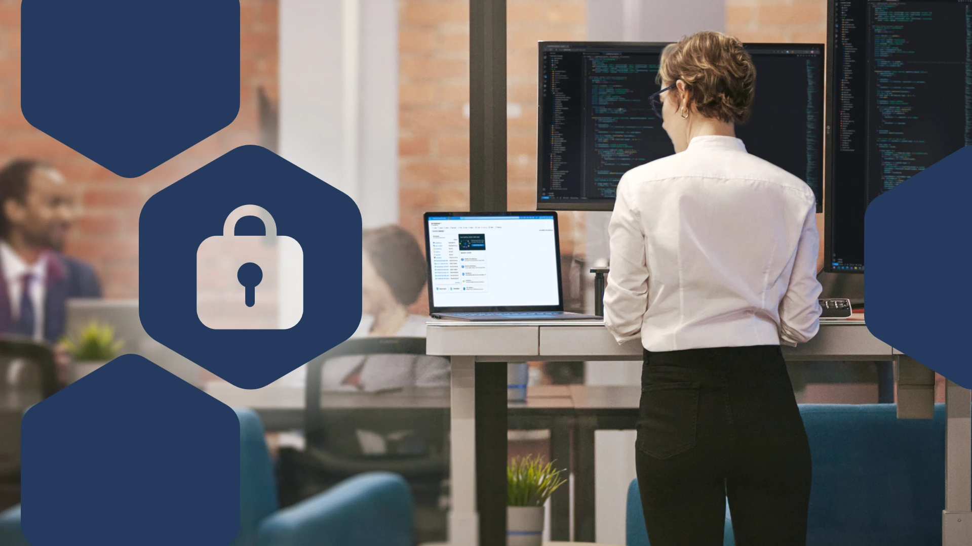 Office worker standing at a desk with multiple computer monitors displaying code, alongside a laptop screen and a lock icon graphic representing cybersecurity or data protection.