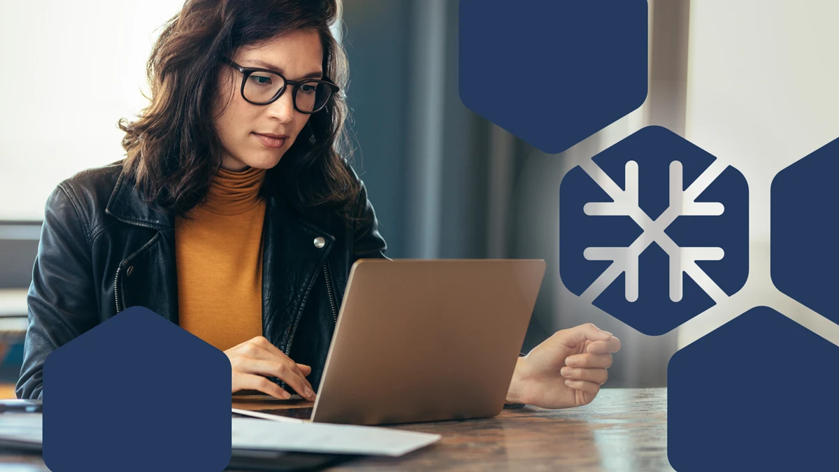 Person using a laptop beside a cloud data platform graphic with a snowflake icon.