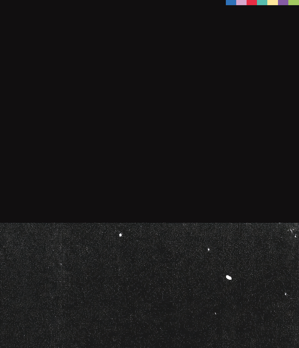 A mostly black image with a speckled gray strip at the bottom, resembling a rough surface. In the top right corner, there are six small horizontal color bars in red, blue, green, yellow, gray, and white.