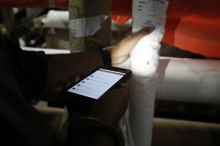 Photo of a phone scanner being pointed at a label on a roll of fabric