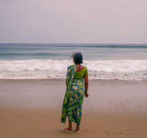 woman standing on the beach looking at the ocean