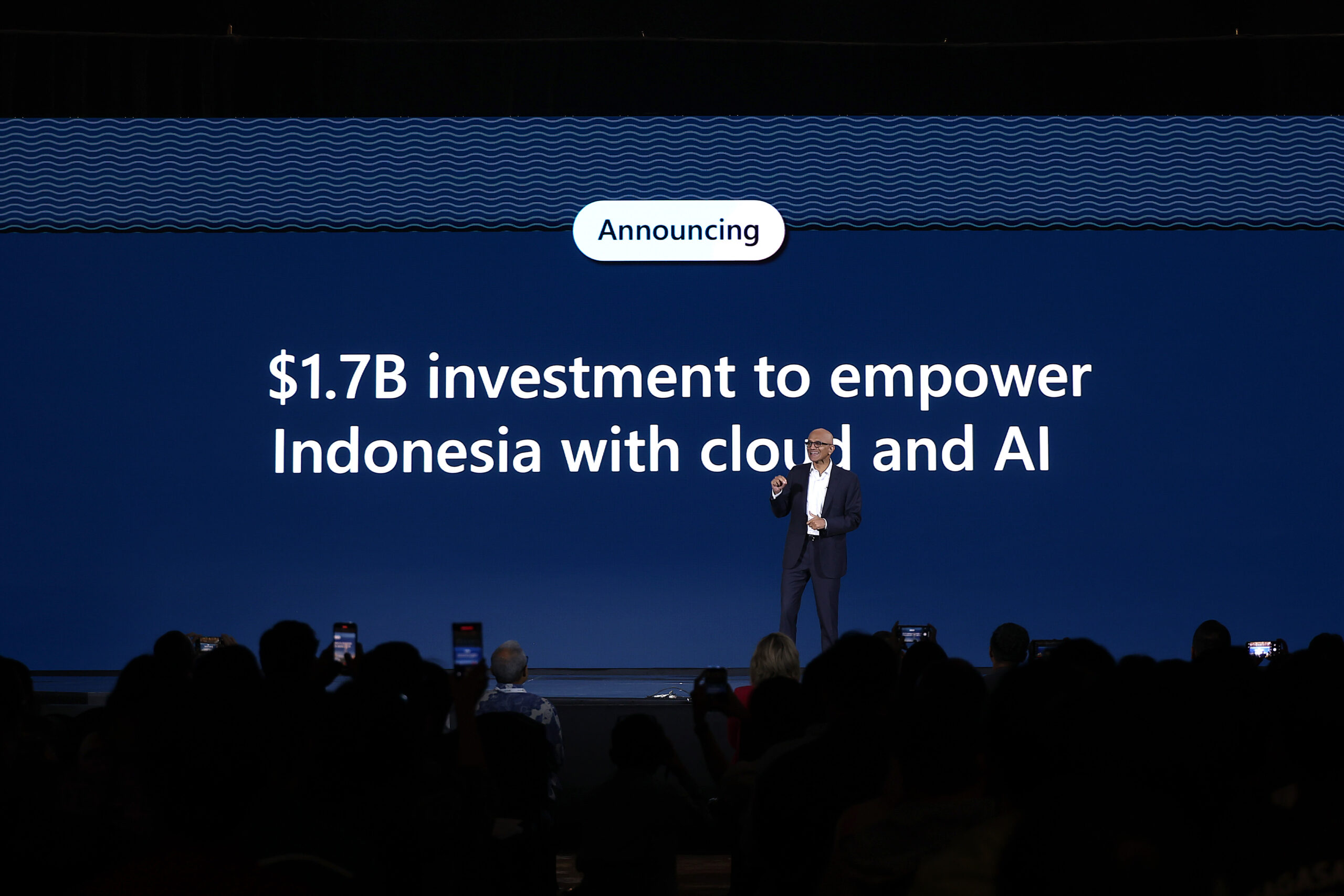A man on stage making an investment announcement in Indonesia