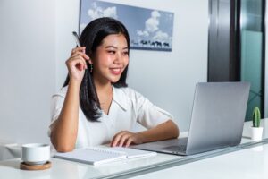 Woman smiling at a laptop on a desk