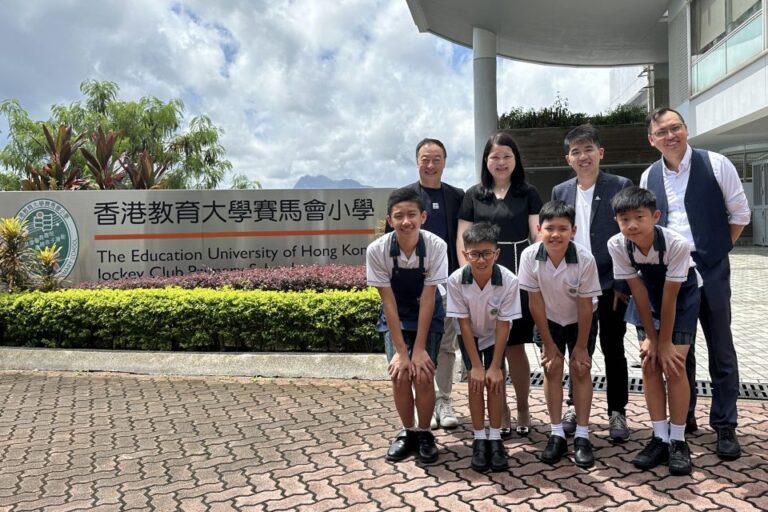 a group of teachers and students standing in front of a wall with The Education University of Hong Kong logo