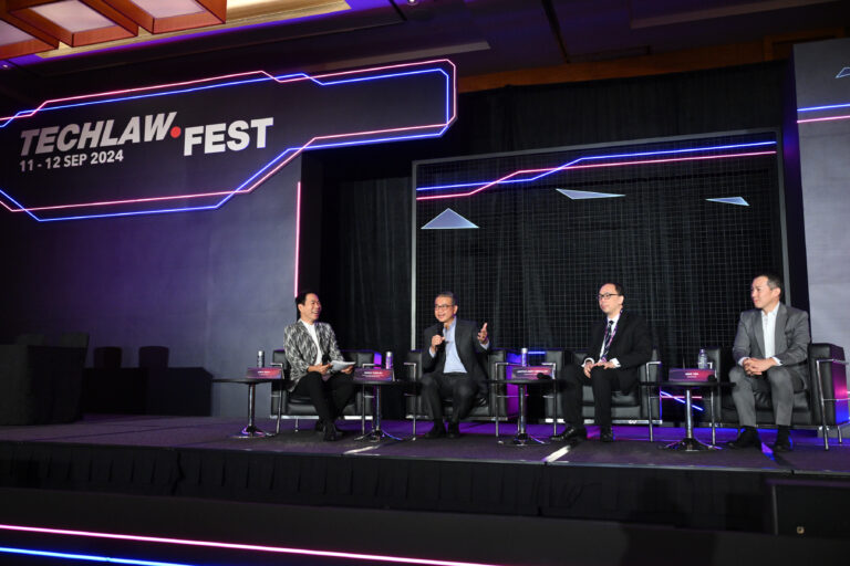 A group of men discussing on stage at a fireside chat