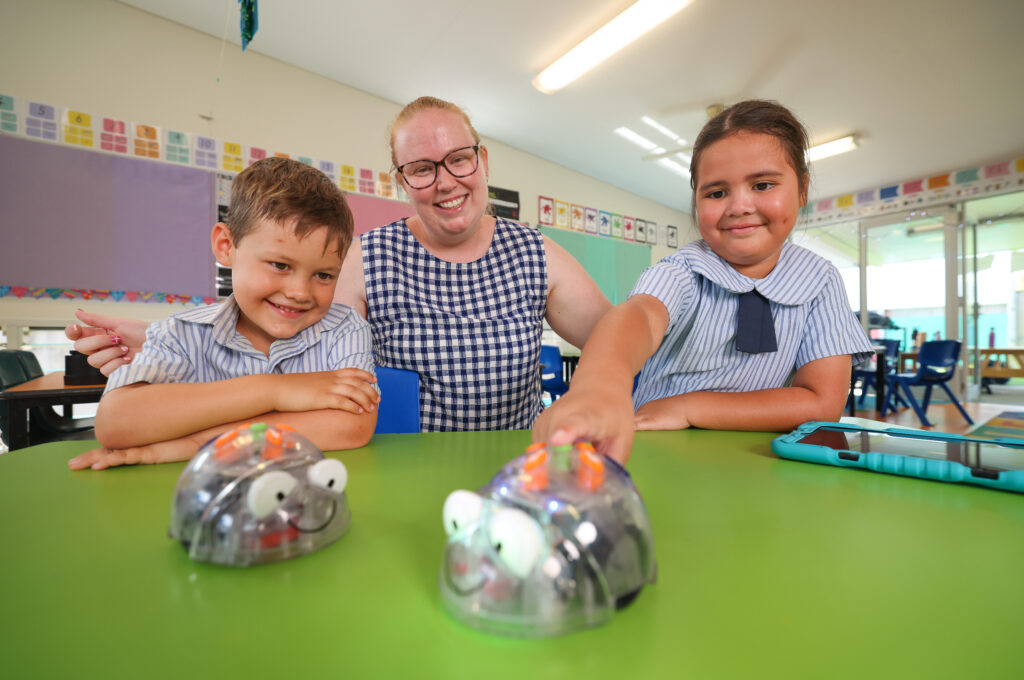 Two students and a teacher learning in a classroom