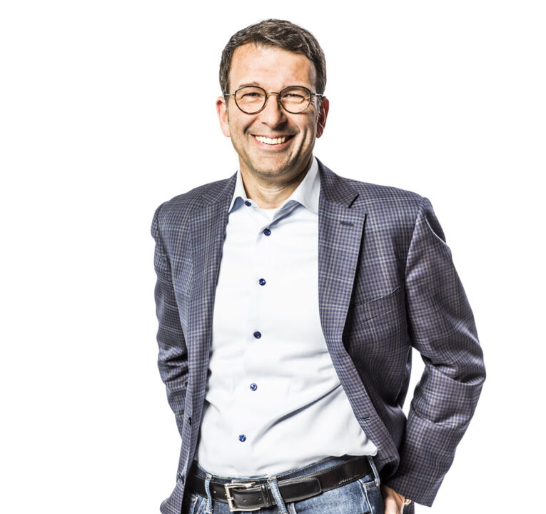 A man with a jacket, with his hands on his wrist