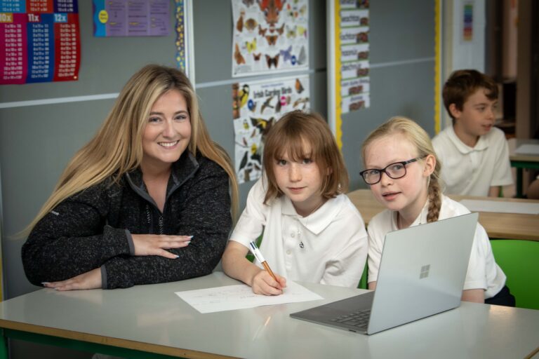 Teacher with two students at a laptop