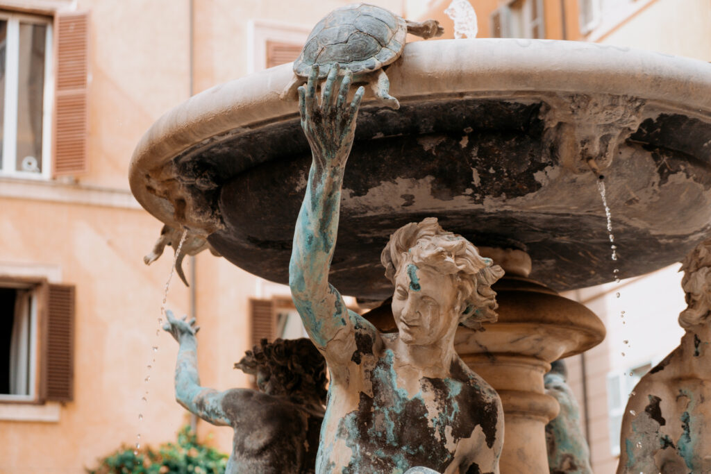 RomeTouristVirtualAssistant-4	A detail of the Fontana delle Tartarughe, or Turtle Fountain, in Piazza Mattei in central Rome. The fountain is fed by an aqueduct built in 19 B.C. Photo by Chris Welsch for Microsoft.	A smiling statue lifts a turtle on a Baroque-style fountain with water flowing from small spouts.