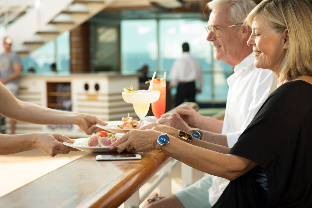 Dos invitados disfrutan de la hora feliz sentados en un bar a bordo de un barco.