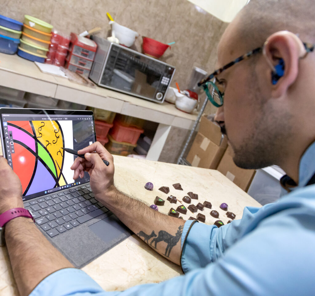 Azgard trabaja en una Microsoft Surface en una cocina con unos chocolates en la mesa