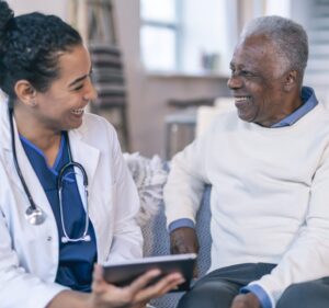 Una doctora habla con un paciente mientras sostiene una tableta