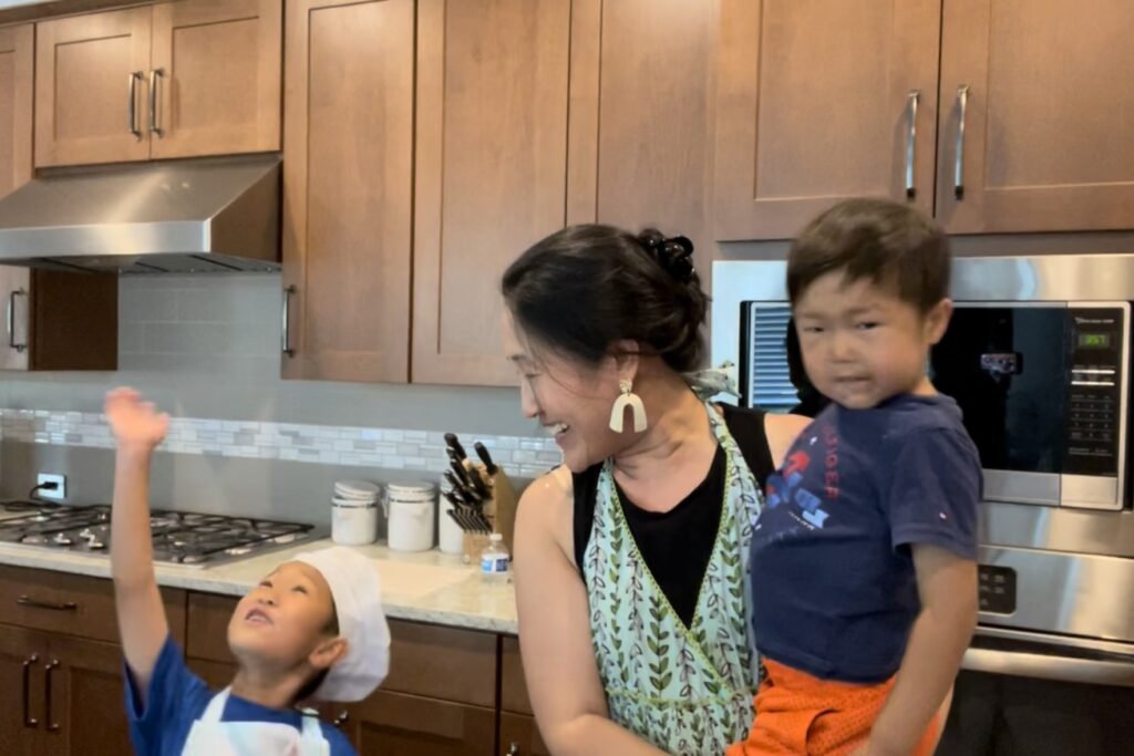 Una mujer con sus dos hijos en la cocina