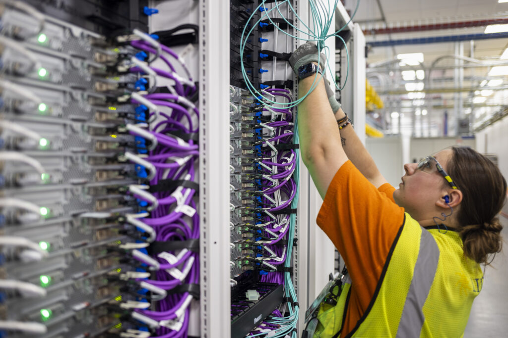 Personal de informática trabajando en un rack de servidores en un centro de datos
