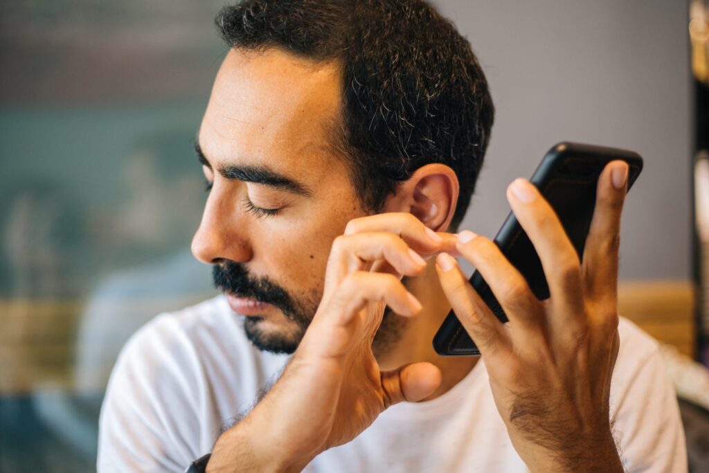 Un hombre escucha su smartphone
