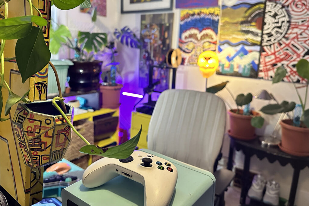 Un control de Xbox en un estudio decorado con pinturas
