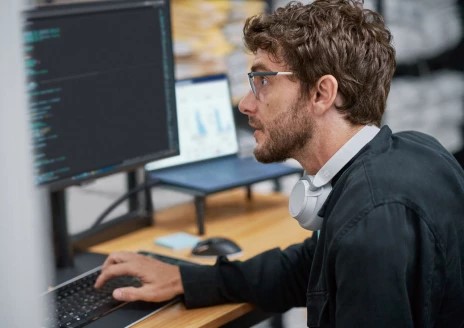 Foto de un empleado masculino usando una computadora portátil en un entorno de negocios pequeños