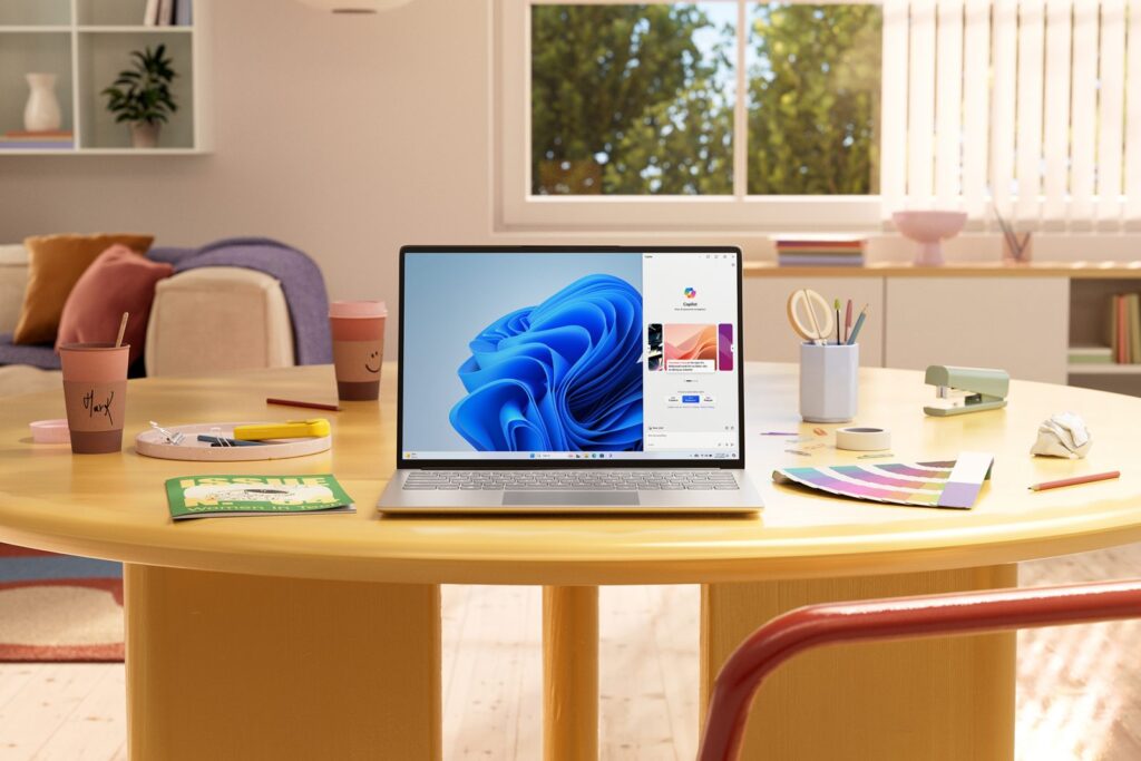 Ilustración de una mesa de trabajo con una laptop que muestra a Copilot en la pantalla, junto a tazas de café y artículos de oficina, en tonos pastel