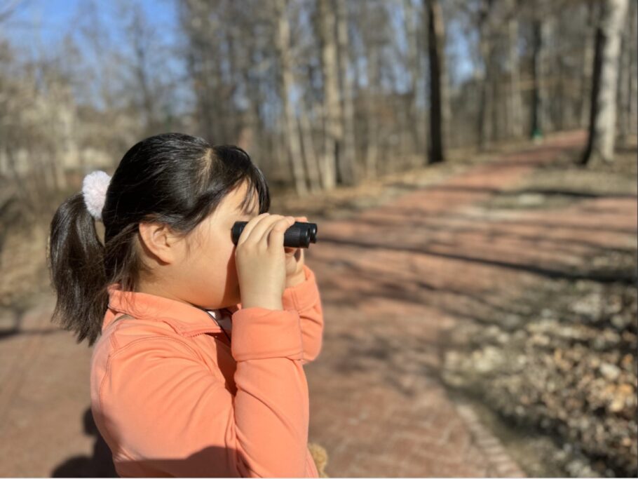 Una niña mira a través de unos binoculares