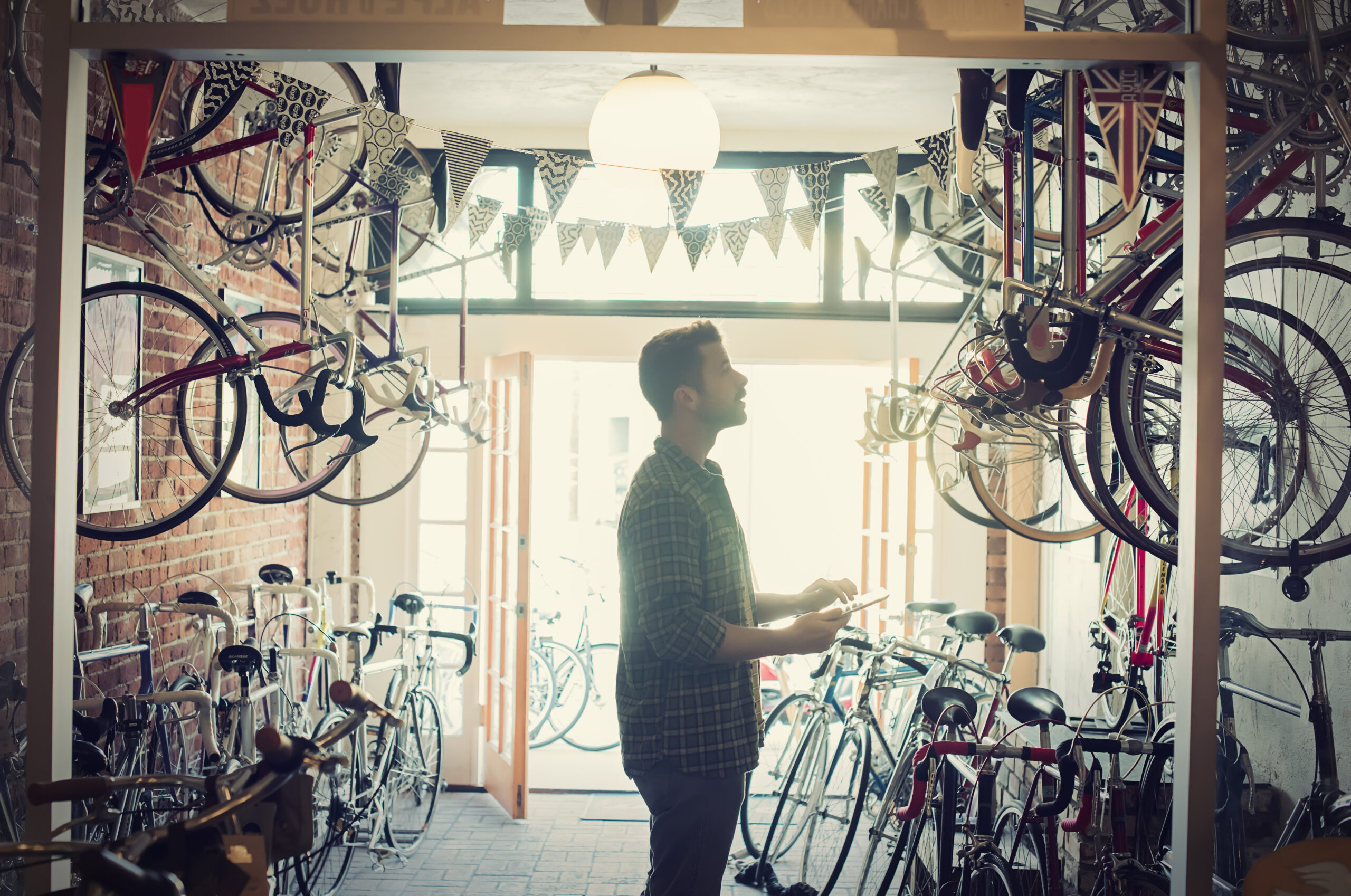 Un hombre sostiene su teléfono en una tienda de bicicletas