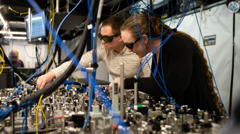 Cientistas da Quantinuum fazendo ajustes em um conjunto de linhas de feixe usado para fornecer pulsos de laser em computadores quânticos da série H.