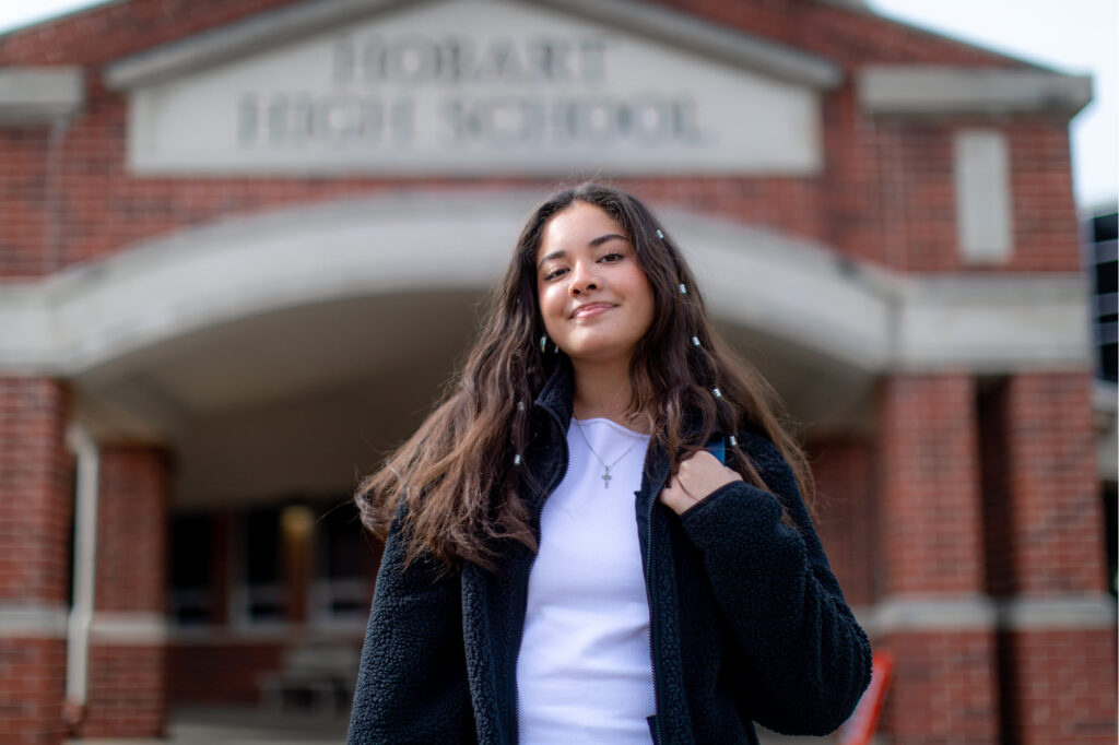 Foto de la estudiante de secundaria, Jzehbel García, de pie afuera de la Escuela Secundaria Hobart.