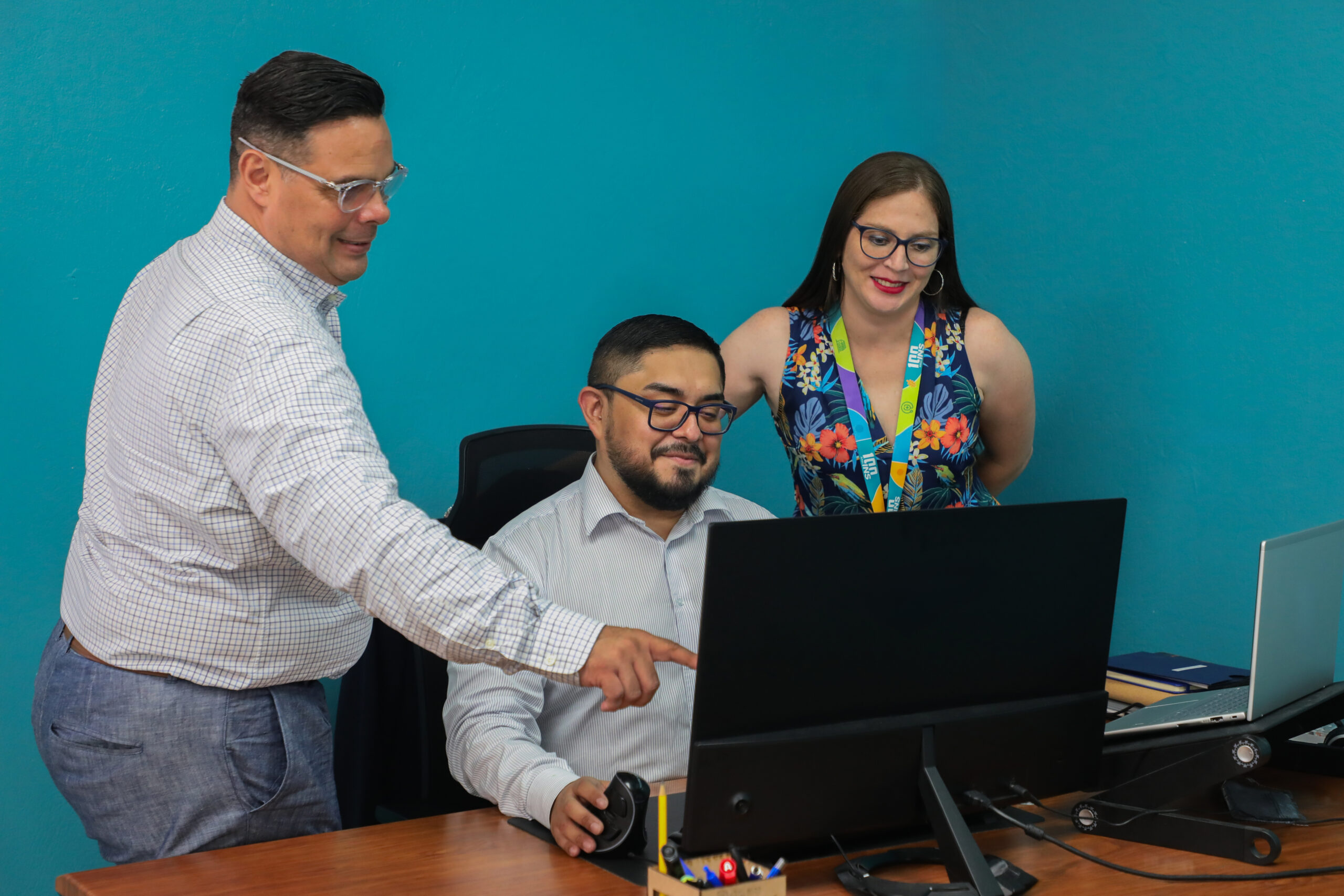 Tres personas frente a una computadora