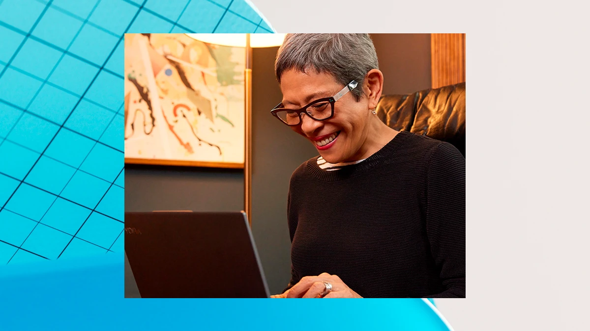 Una mujer con lentes frente a una laptop