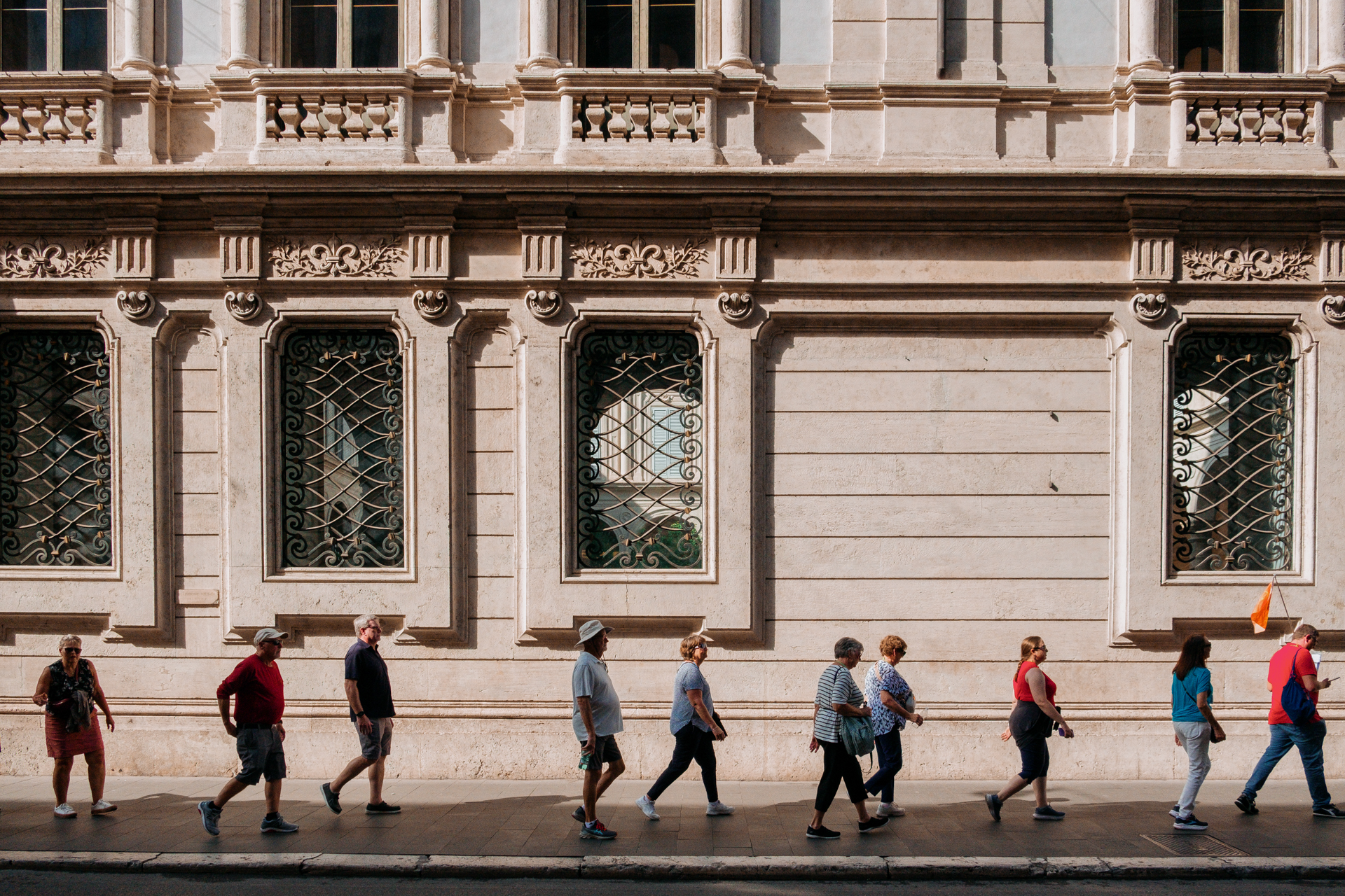 Grupo de turistas camina por las calles de Roma, Italia