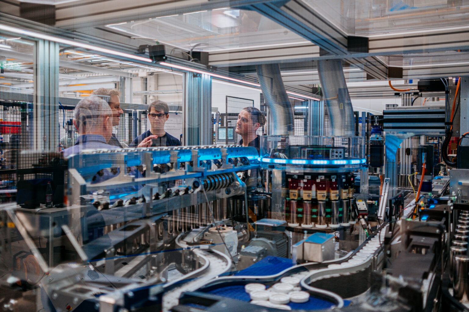 Frente a la cámara, Paul Kempt, programador de thyssenkrupp, a la izquierda, y Marcus Schoenherr, ingeniero de thyssenkrupp, con la máquina de pruebas de celdas de batería para vehículos eléctricos.