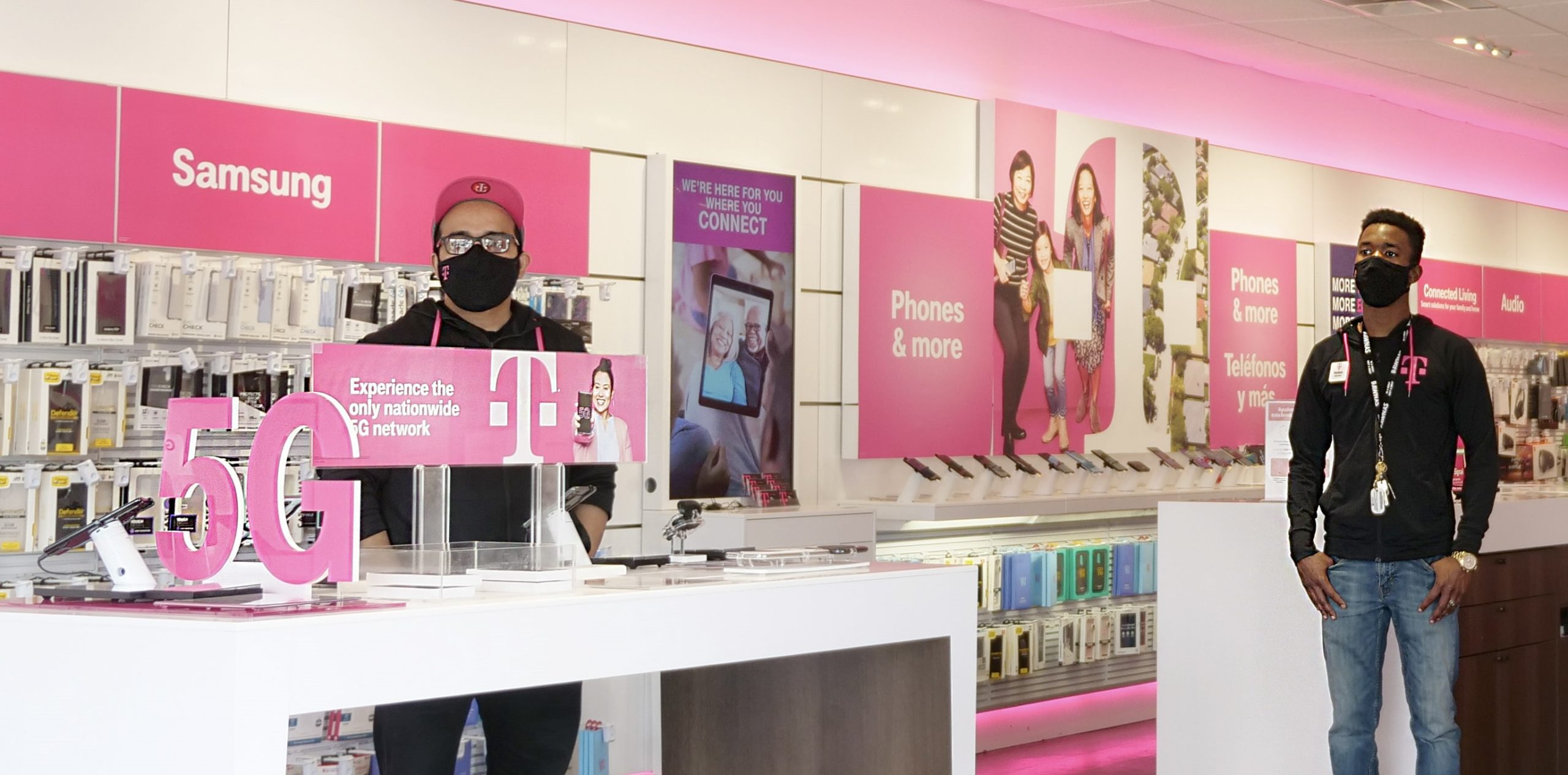 Photo of two male employees inside a T-Mobile store.