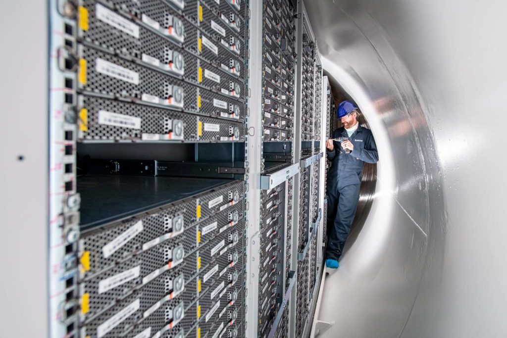 A man stands inside the Northern Isles datacenter removing a server