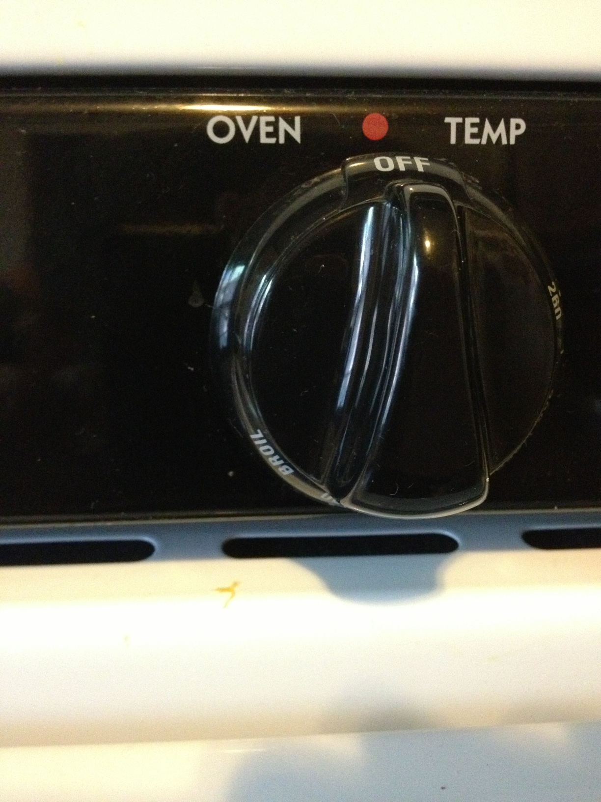 Black oven temperature knob that is currently in the off position.