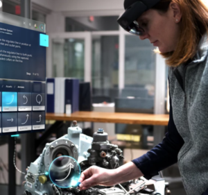 Woman wearing HoloLens to work on an engine