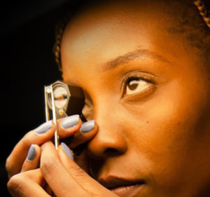 Woman examining a diamond through a jewelry magnifier