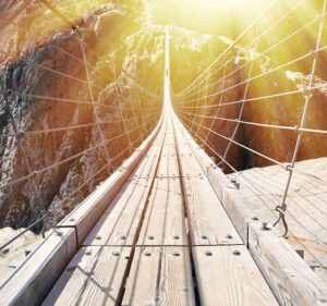 Rope and wooden walking bridge across a deep chasm
