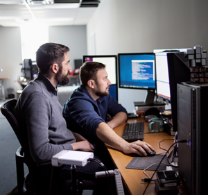 Two men working on desktop computers in an office