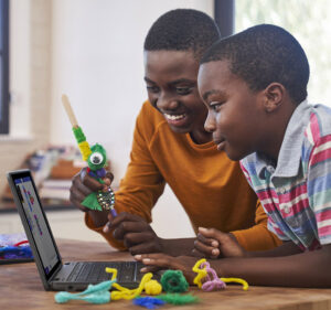 Two boys en joying learning toys and their laptop computer