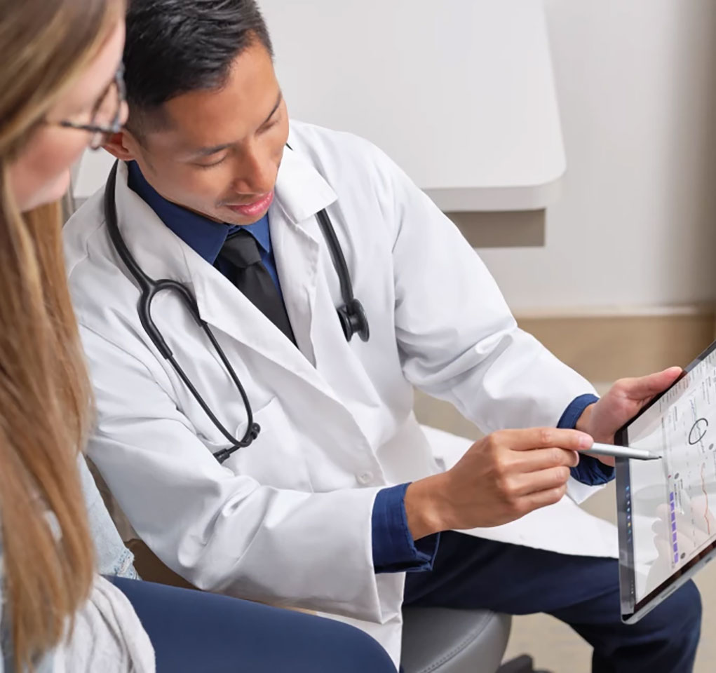 Doctor discusses healthcare information on a tablet device withy his patient