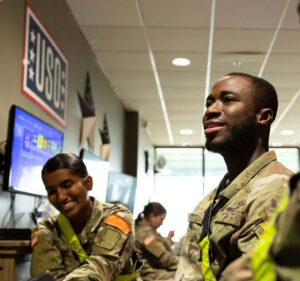 Three soldiers relaxing in a room with a USO sign on the wall